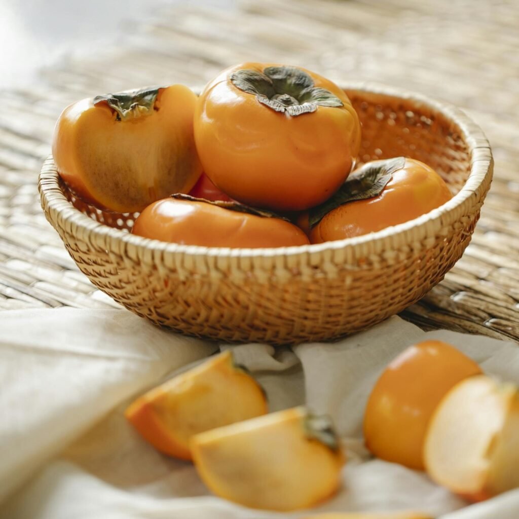 Ripe persimmons on wicker surface