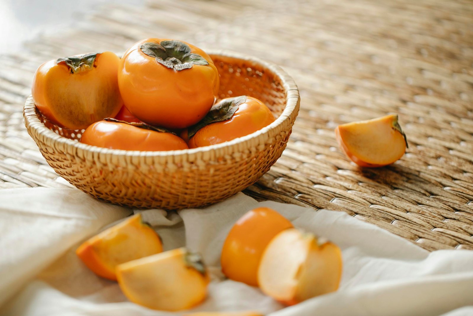 Ripe persimmons on wicker surface